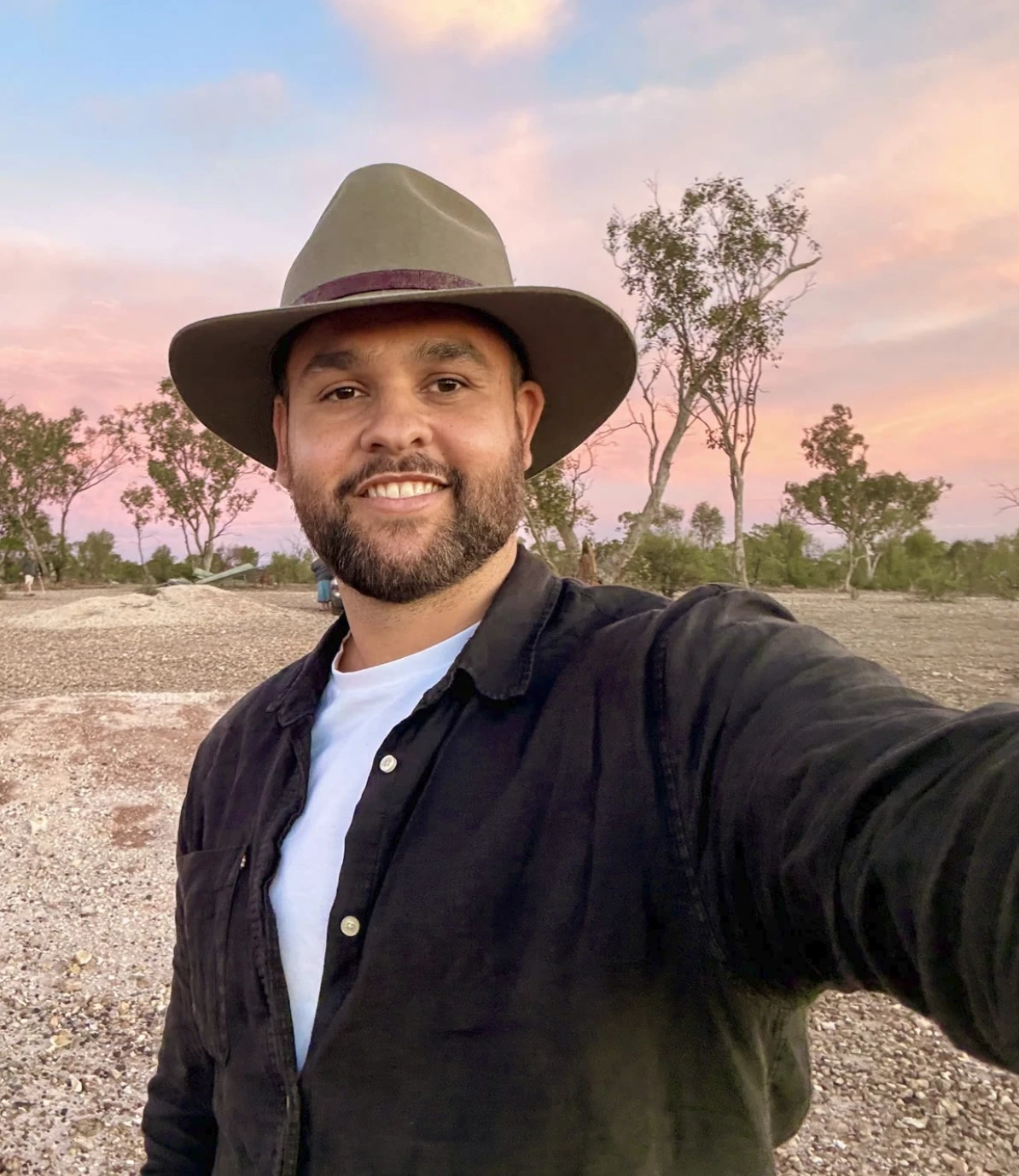 James Saunders in a wide-brimmed hat in the outback at sunset